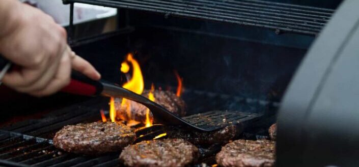 Person Grilling Burger Patties
