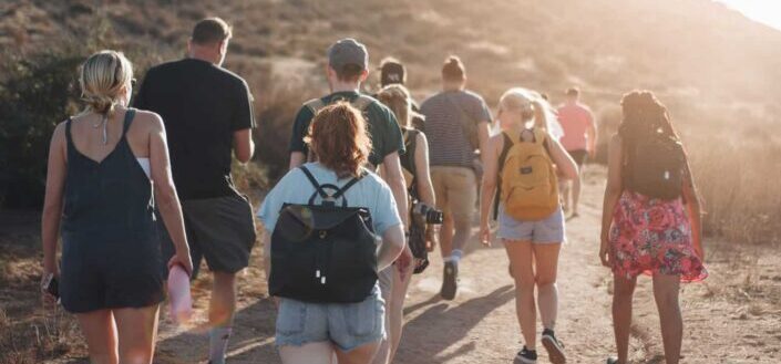 People Walking on Dirt Road Near Mountain